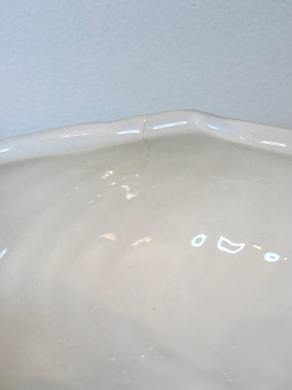A glossy white ceramic pedestal bowl with a fluted, ribbed exterior and wavy rim, displayed on a white marble surface against a light gray background., photo 4