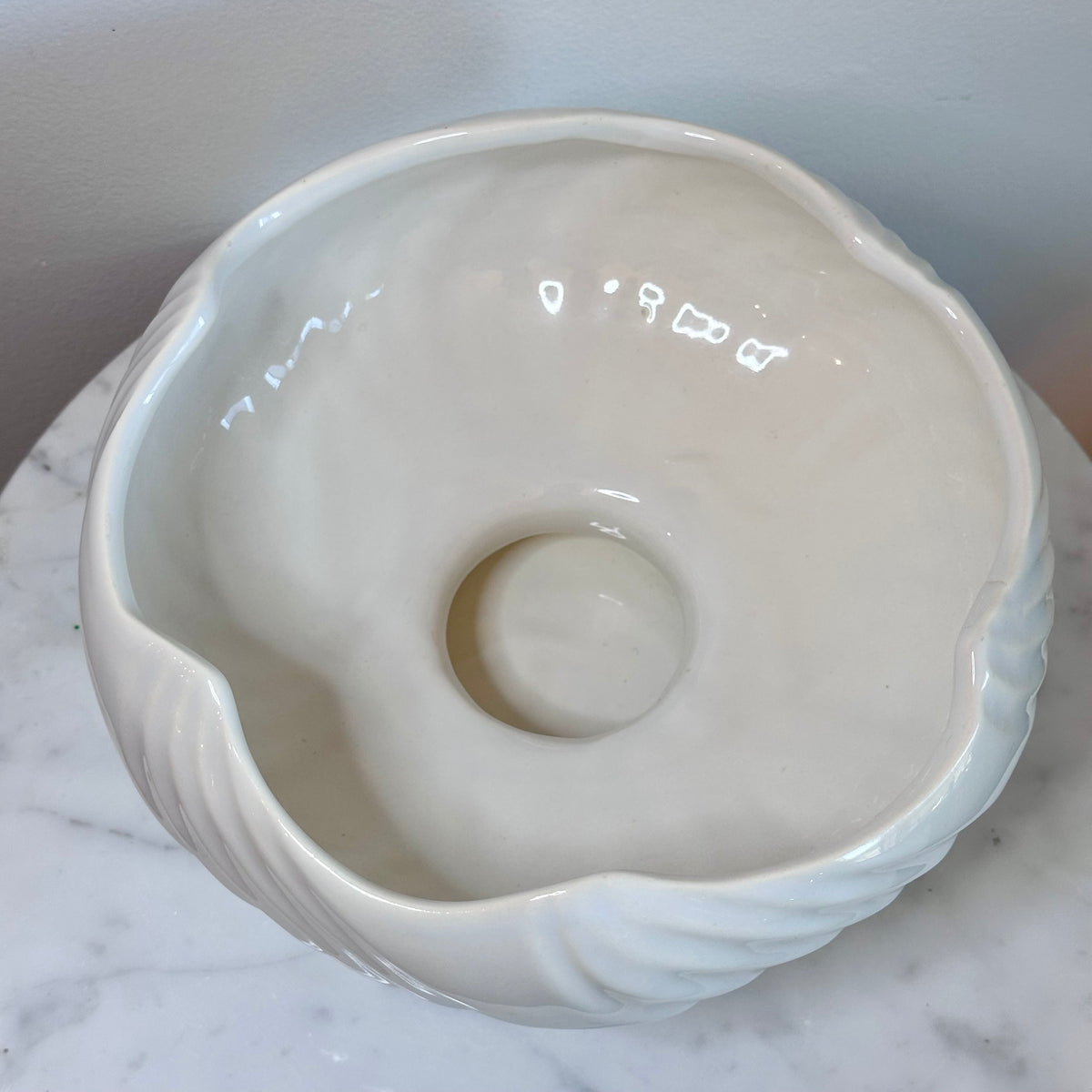 A glossy white ceramic pedestal bowl with a fluted, ribbed exterior and wavy rim, displayed on a white marble surface against a light gray background., photo 5