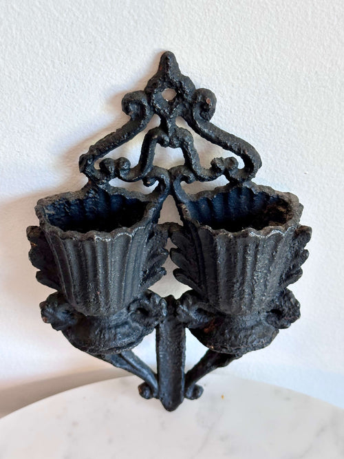 An antique black cast iron double urn match safe with black scroll work and striking plate down the center.