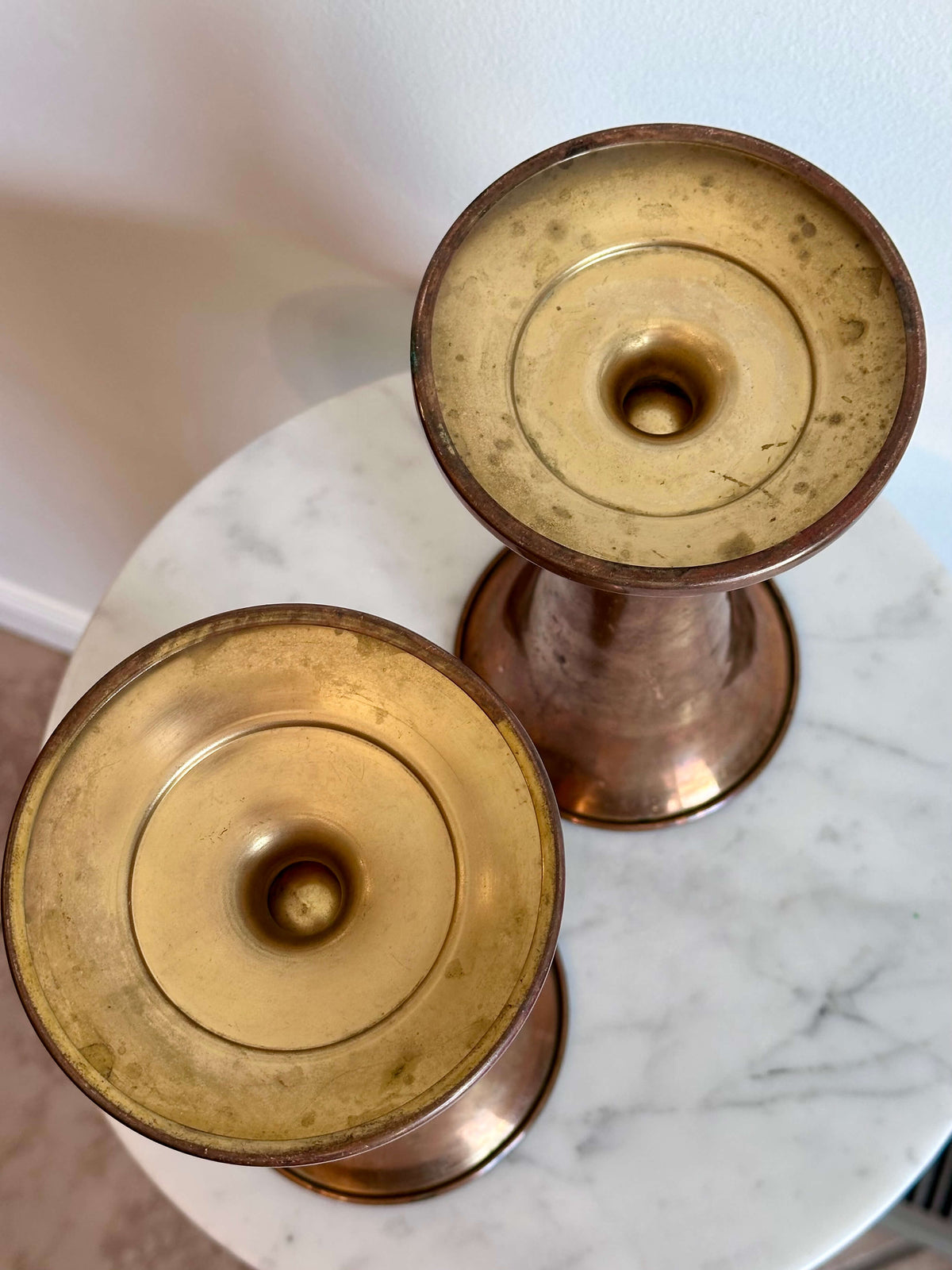Bottom view of Vintage Brass Trumpet Style Church Altar Vase displayed on a white marble surface against a plain white wall.