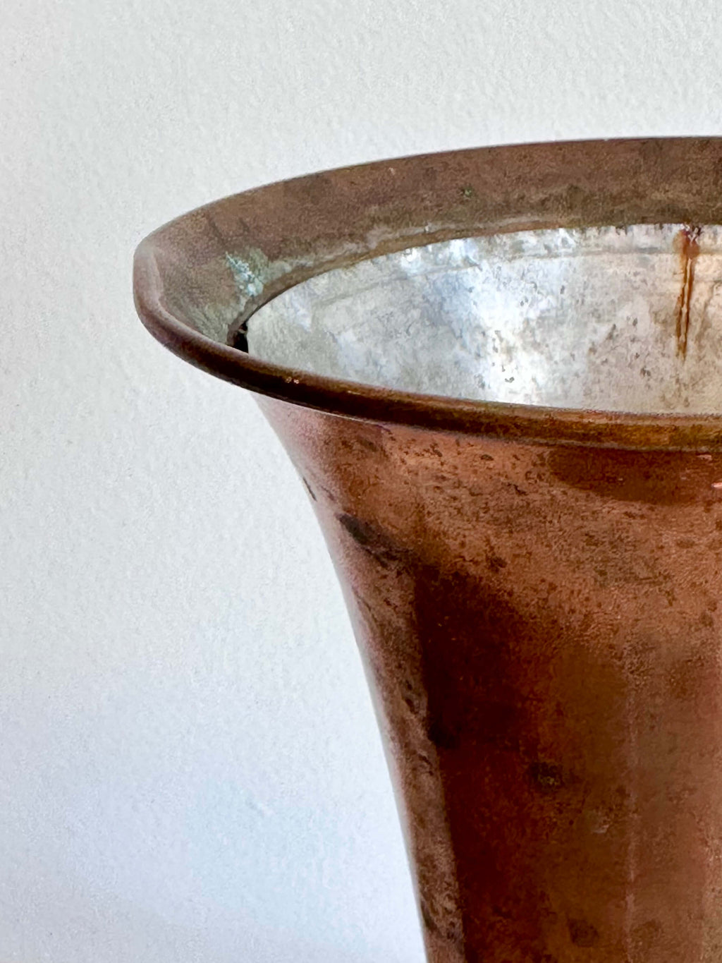 Close up of Vintage Brass Trumpet Style Church Altar Vase displayed on a white marble surface against a plain white wall.